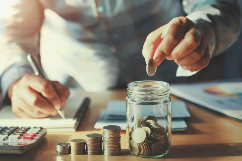  A man saving up money in a jar and calculating expenses