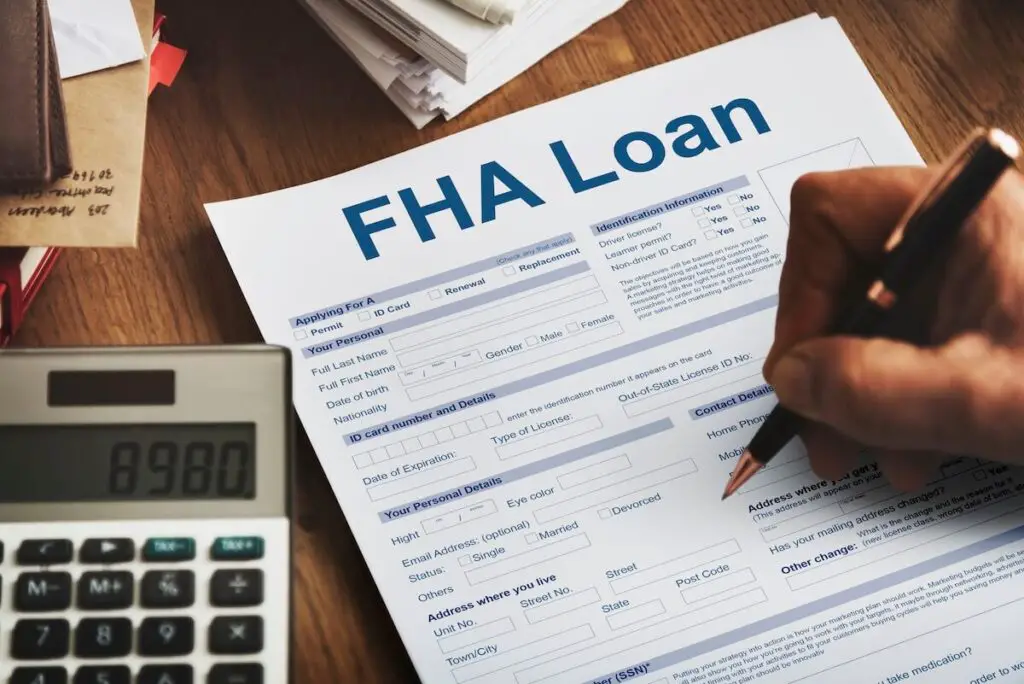 A person off-screen filling out an FHA loan form