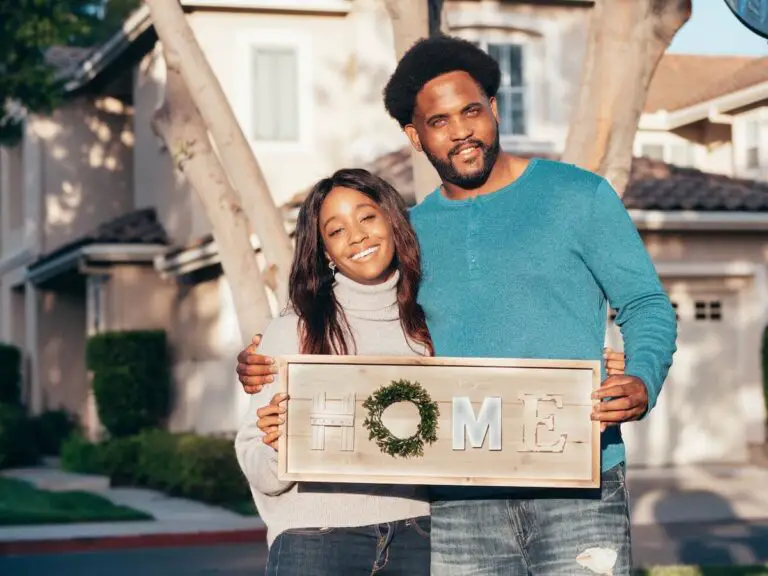 Couple holding a home sign