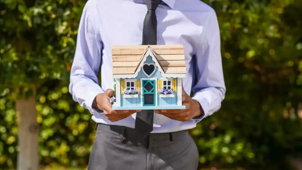 Man holding a model of the house