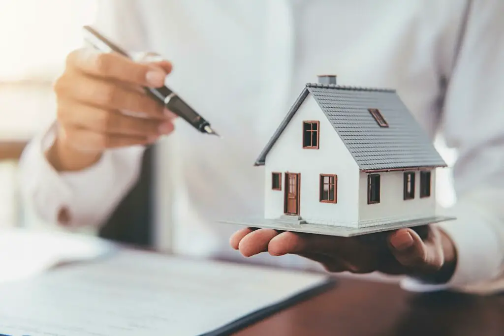 A man holding a model of a house.