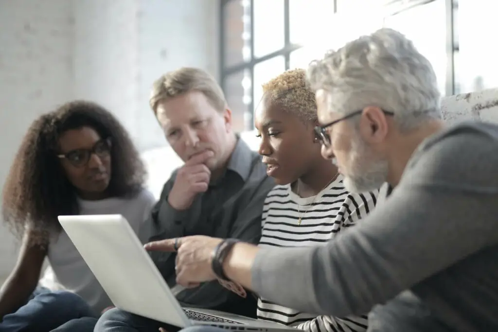 A group of people looking at a laptop