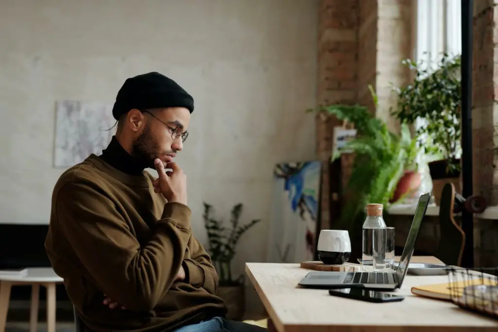 A man thinking while looking at his laptop