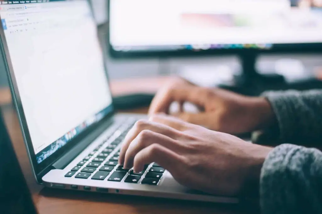 A person typing something on a laptop