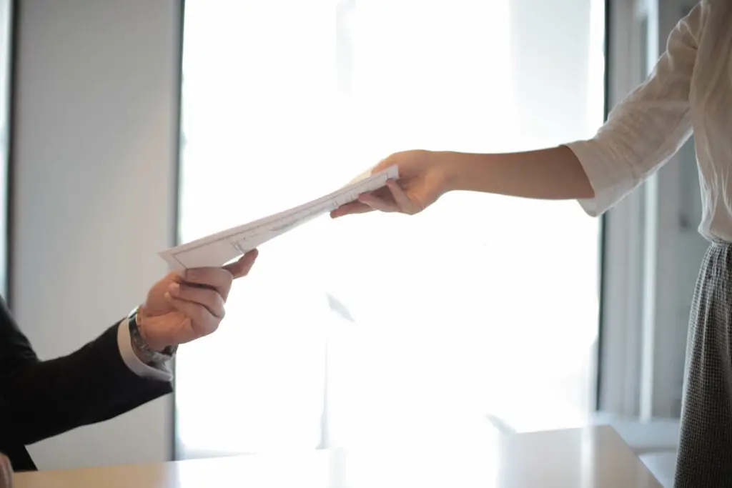 A woman handing over a paper