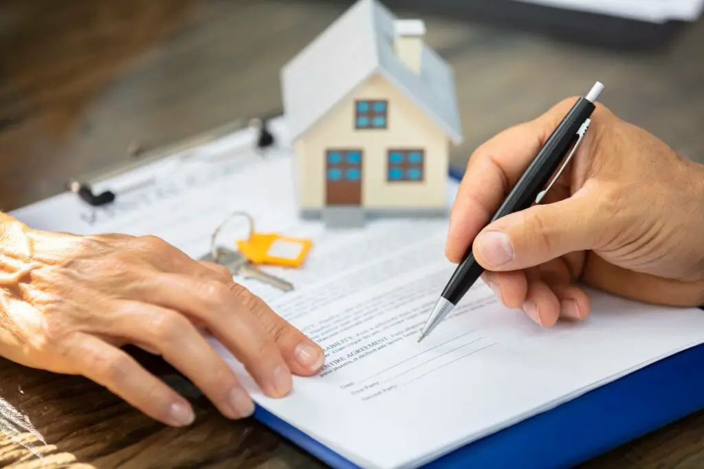 Two people signing papers for a loan