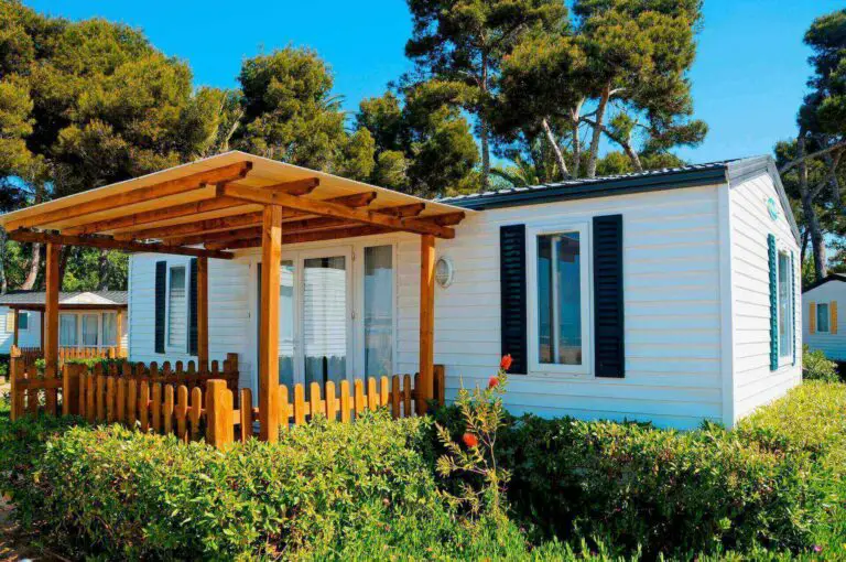 White mobile home with wooden canopy
