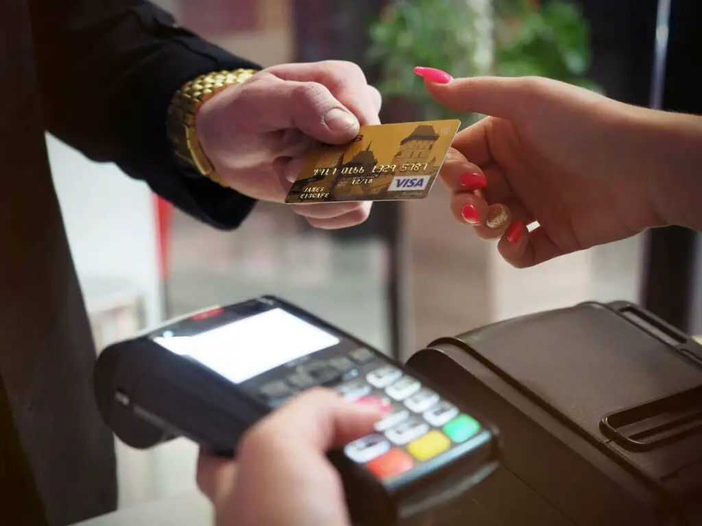 Woman holding credit card and POS terminal