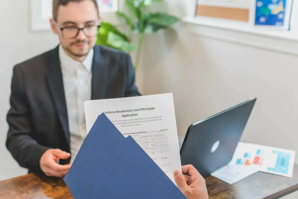 A worker in a loan company giving clients their paperwork