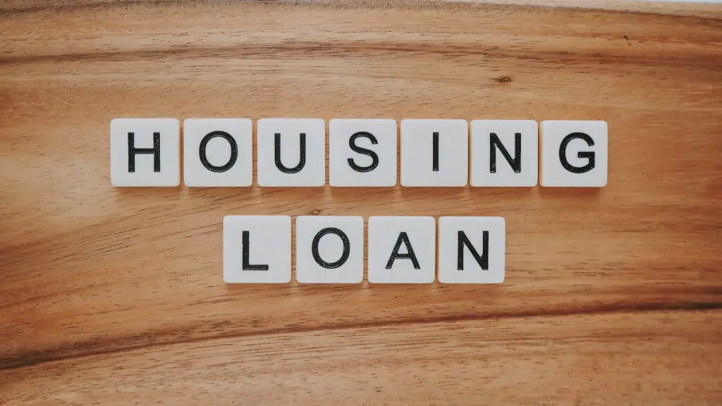 The words 'housing loan' spelled out on a wooden table