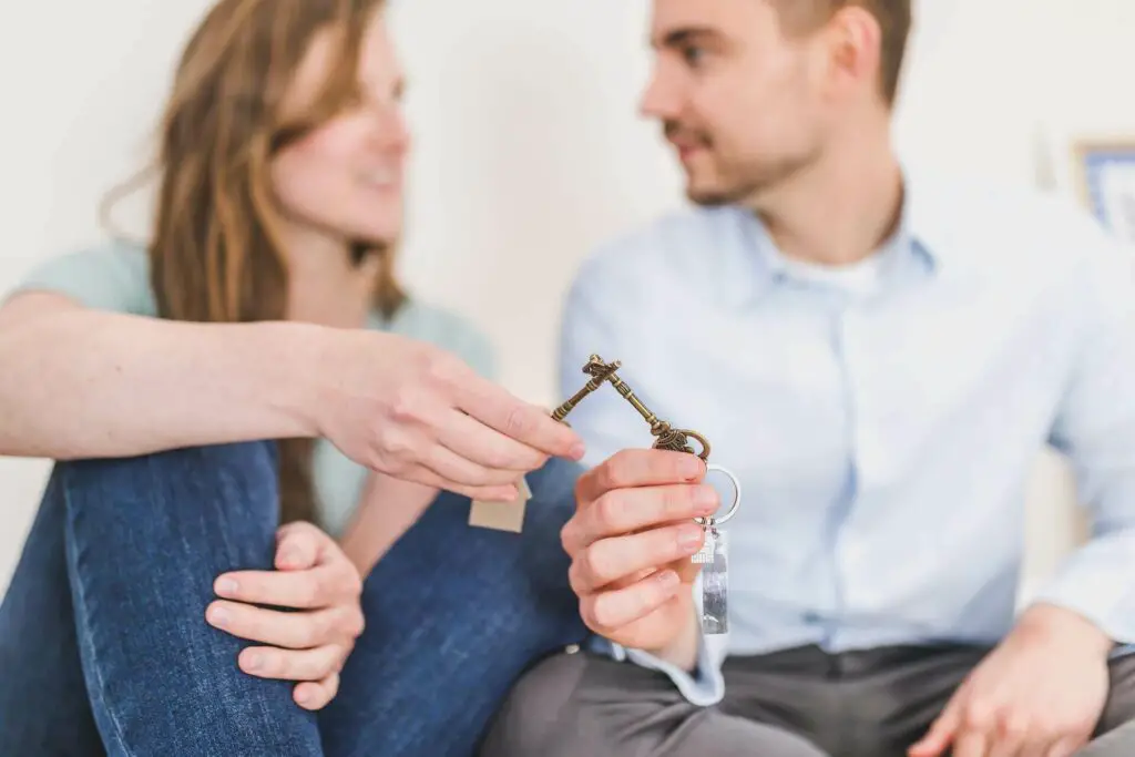 Woman and men holding keys of their home 