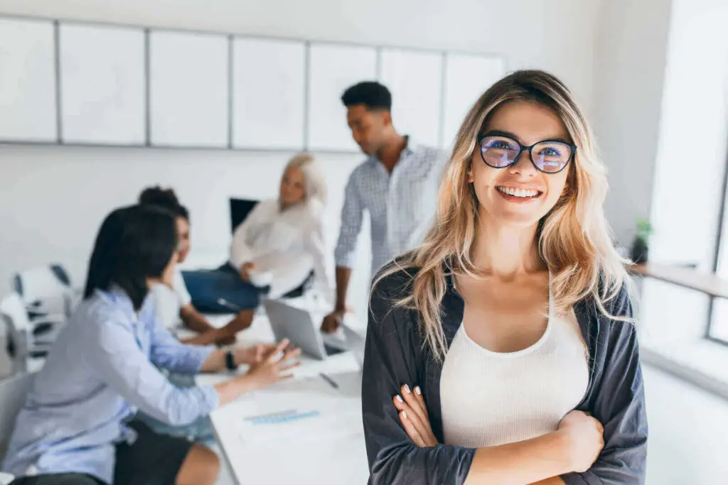 Woman smiling in front of people that are sitting at a table