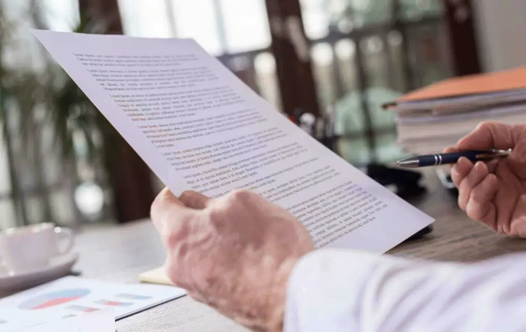 A person holding a paper and a pen