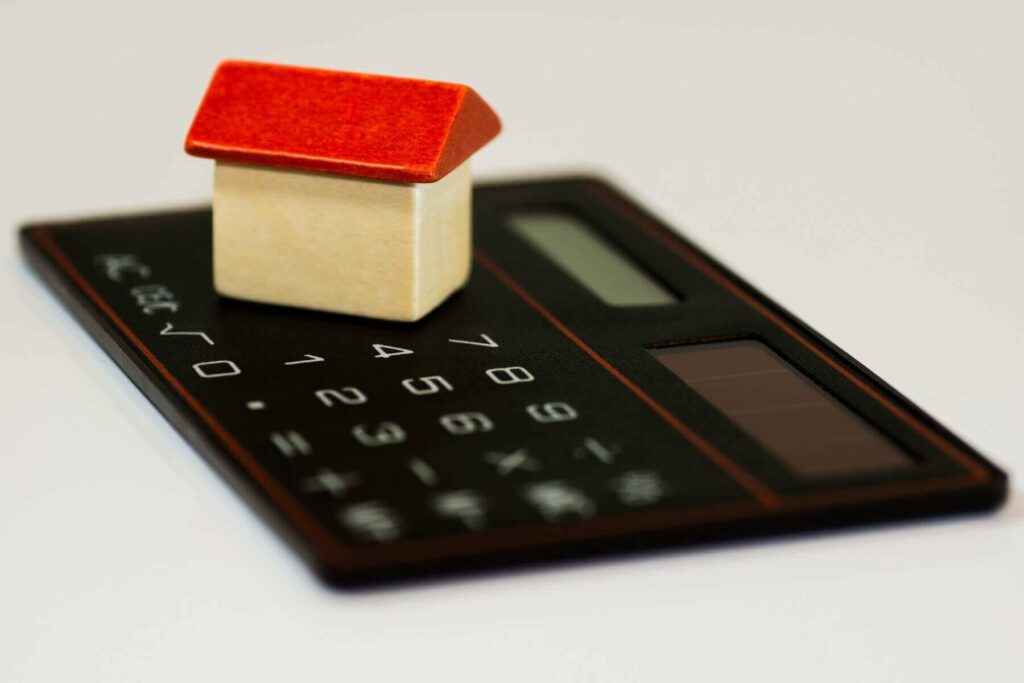 A small toy in the shape of a house on a calculator